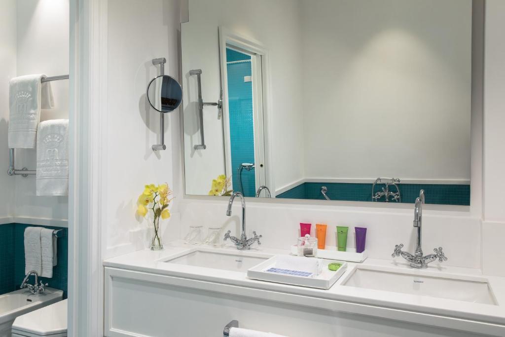 a bathroom with two sinks and a mirror at Grand Hotel Ambasciatori in Sorrento