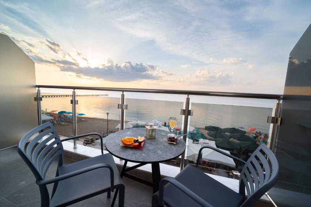 d'une table et de chaises sur un balcon avec vue sur l'océan. dans l'établissement Atlantis ''Pleasure by the Sea'', à Peraia