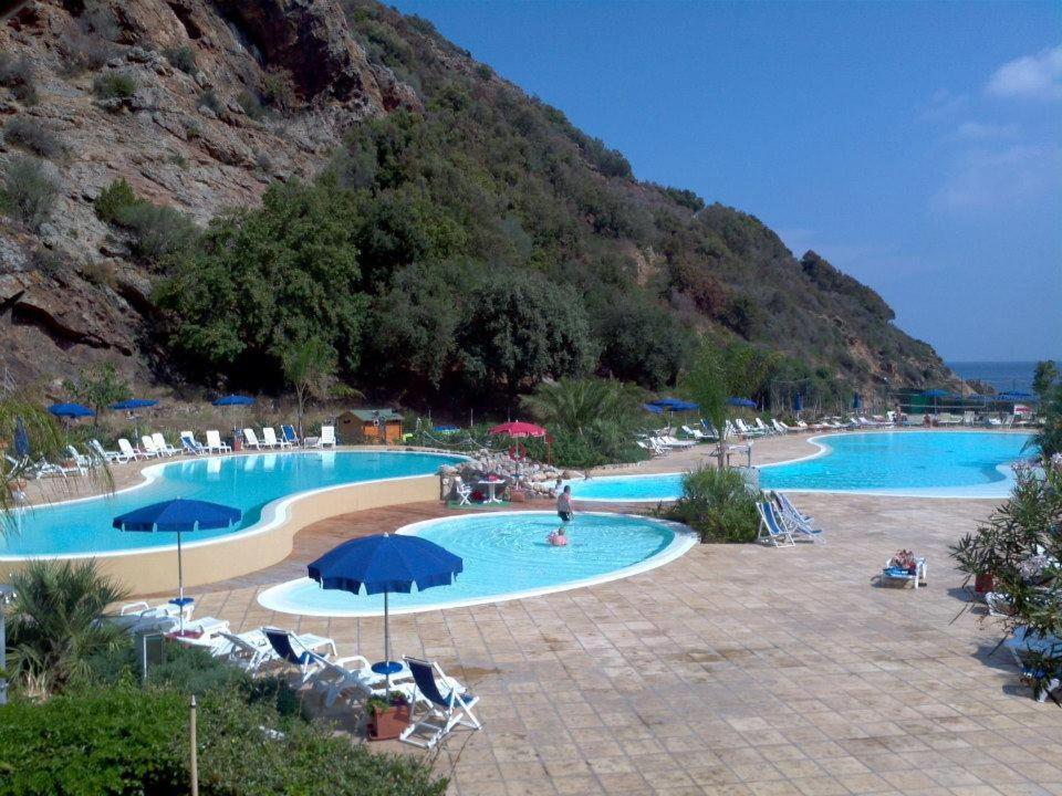 a large swimming pool with chairs and umbrellas at Elba in relax in Rio Marina