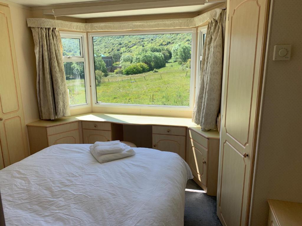 um quarto com uma cama em frente a uma janela em Private Countryside Holiday Cabin 10 mins from Brighton em Brighton & Hove