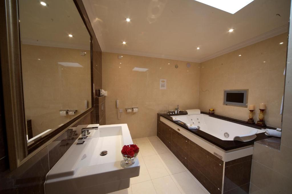 un ampio bagno con vasca e grande vasca da bagno di The Fairview Boutique Hotel a Killarney