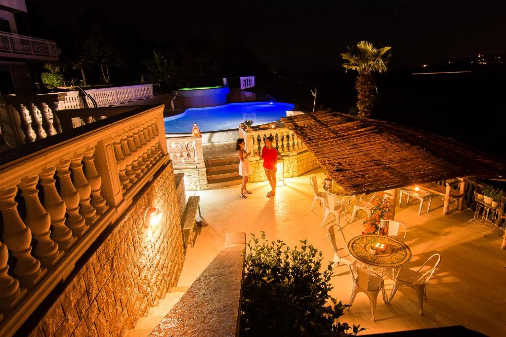 two people walking down a patio at night at Guesthouse SOLE in Piran