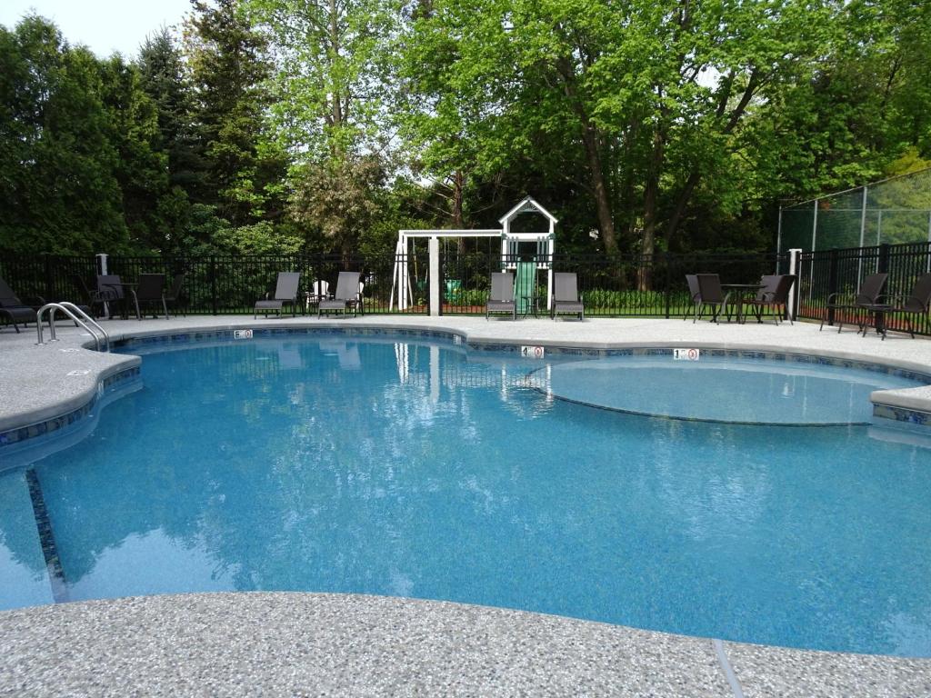 a large pool with blue water in a yard at Pink Blossoms Resort in Ogunquit