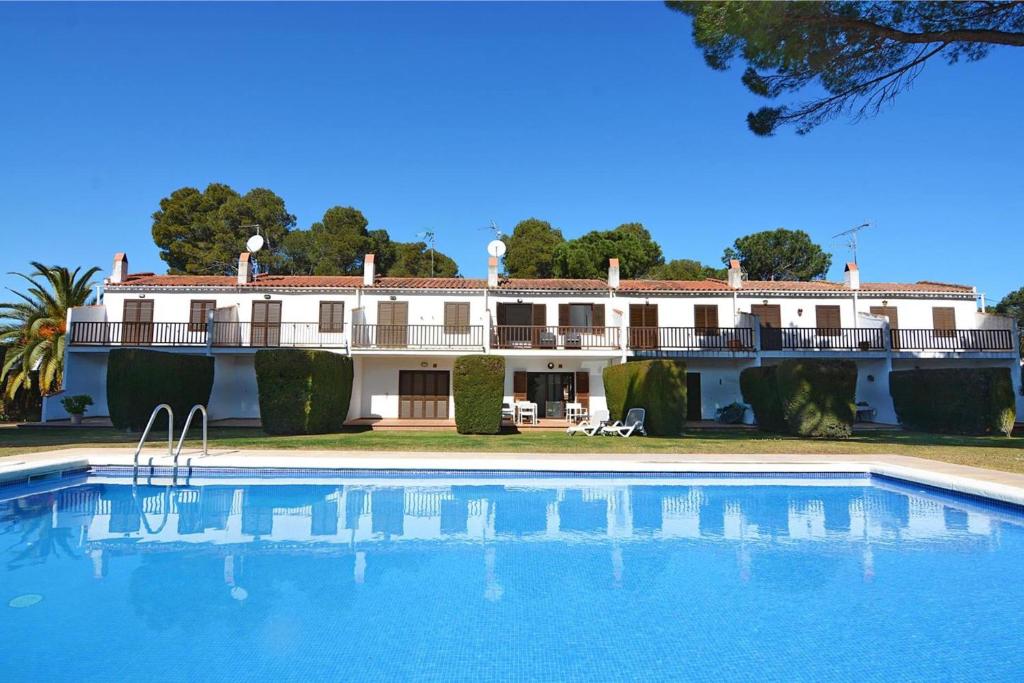 uma villa com piscina em frente a um edifício em Holiday Home Gardenia em L'Escala