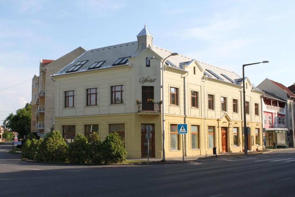 a white building with solar panels on the roof at Spirit Apartman in Hajd&uacute;szoboszl&oacute;
