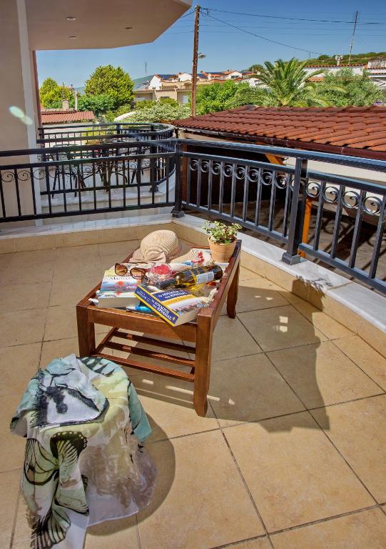 a table on top of a balcony with a view of a roof at Konstantina & Evgenia Deluxe Apartment in Nea Peramos