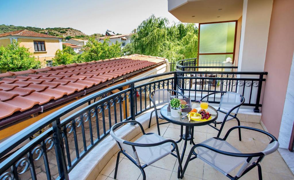 a balcony with two chairs and a table with fruit on it at Konstantina & Evgenia Deluxe Apartment in Nea Peramos