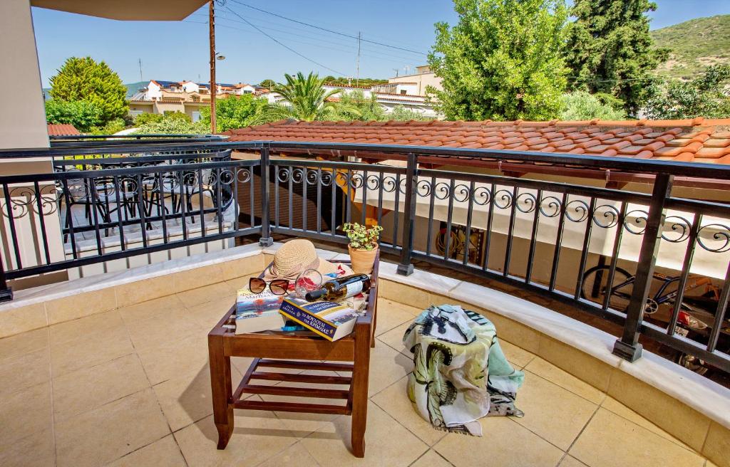 a small table on a balcony with a table at Konstantina & Evgenia Deluxe Apartment in Nea Peramos