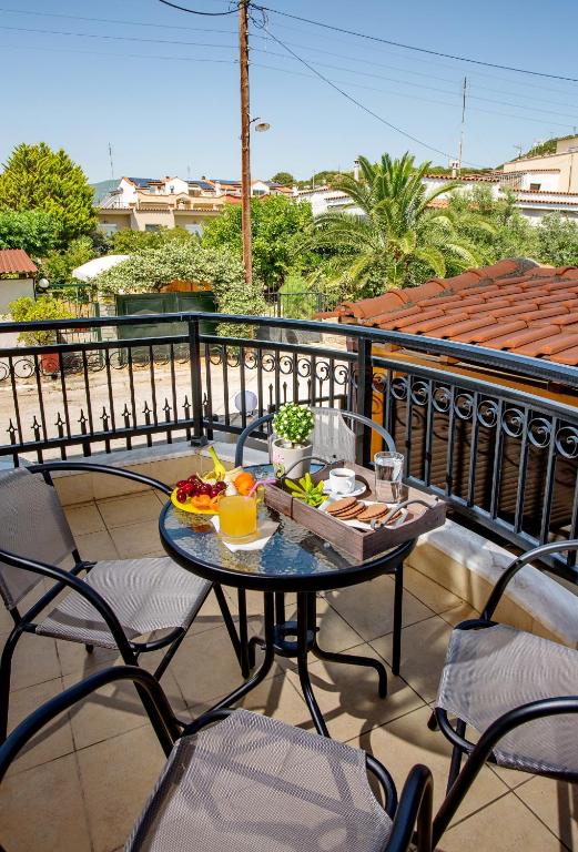 a table with a tray of food on a balcony at Konstantina & Evgenia Deluxe Apartment in Nea Peramos