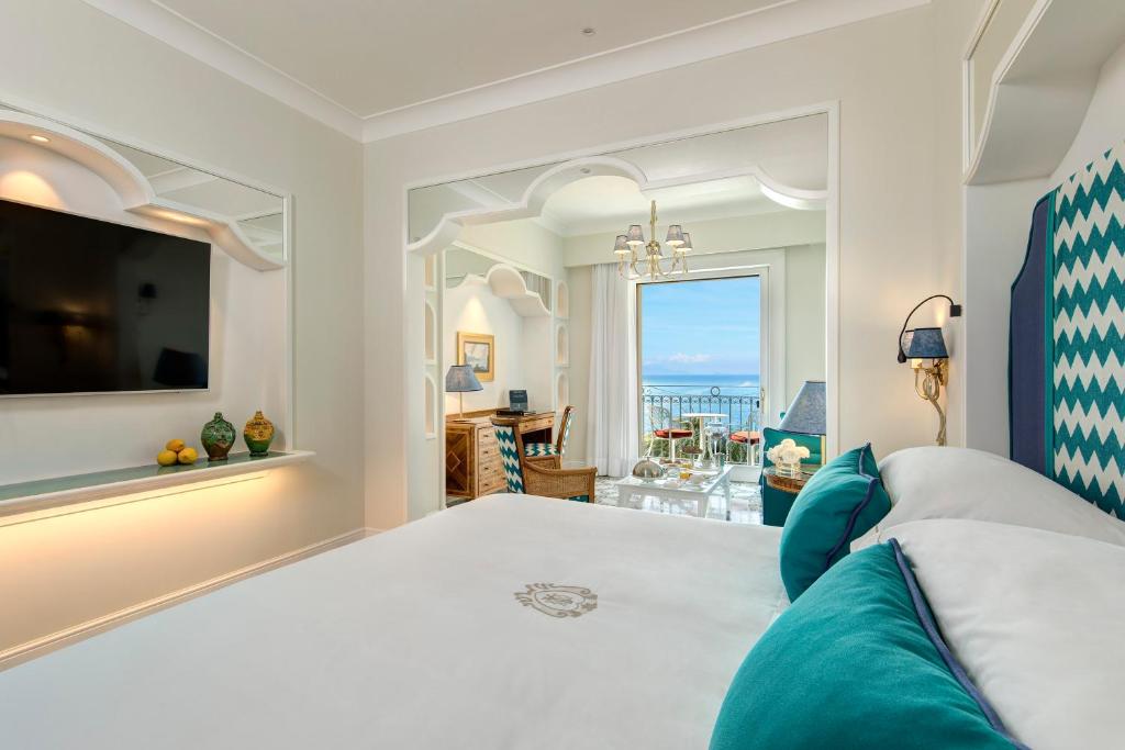 a bedroom with a large bed and a view of the ocean at Grand Hotel Ambasciatori in Sorrento