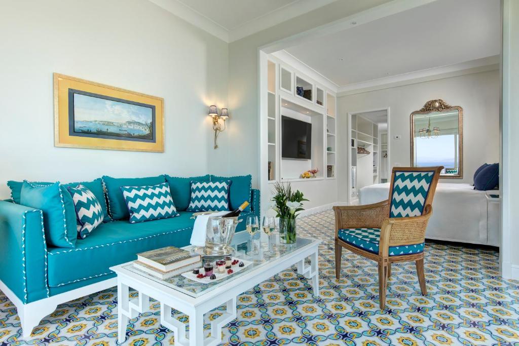 a living room with a blue couch and a table at Grand Hotel Ambasciatori in Sorrento