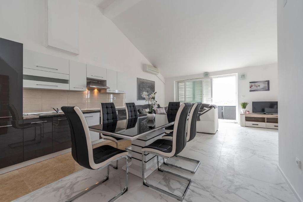 a kitchen and dining room with a table and chairs at Beautiful penthouse for 8 close to city center in Novalja
