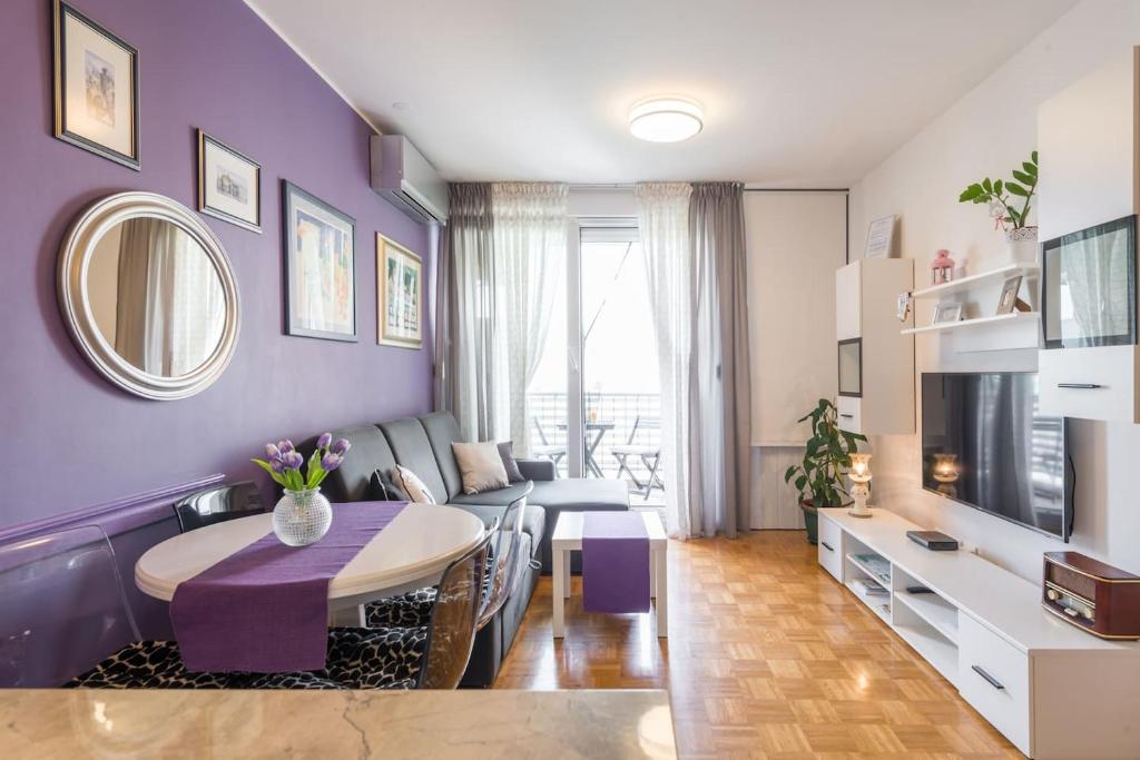 Sala de estar de color púrpura con mesa y sofá en Apartman "Bubi" en Split