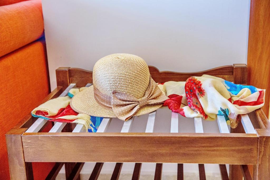 a hat sitting on top of a crib with towels at Konstantina & Evgenia Deluxe Apartment in Nea Peramos
