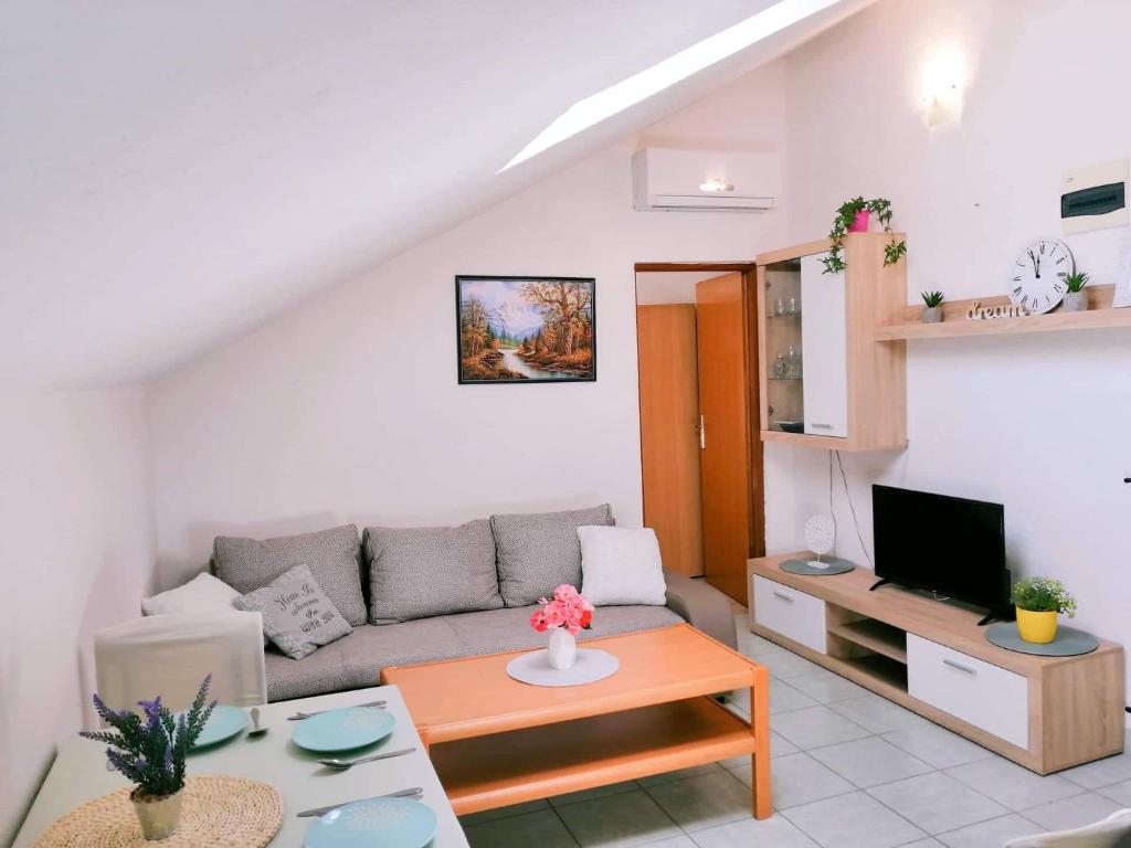 una sala de estar con un sofá y una mesa en Apartments Nevistic, en Tribalj