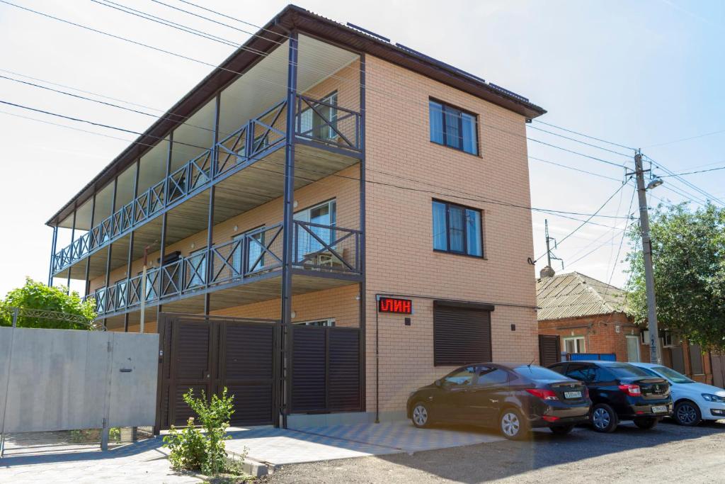 a building with two cars parked in front of it at Гостевой дом Калинина 147 in Yeysk