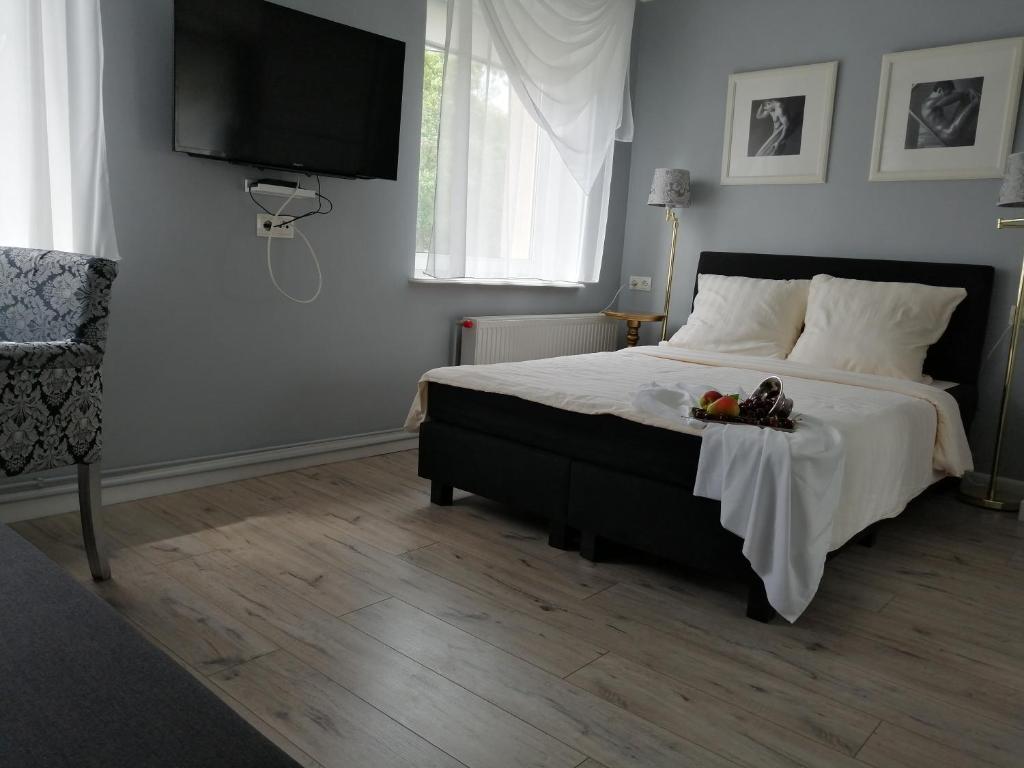 sypialnia z łóżkiem z telewizorem na ścianie w obiekcie Mieszkania na wydmach w Dziwnowie