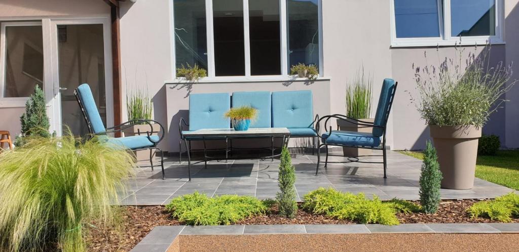 um pátio com cadeiras azuis e uma mesa em Sombor 19 Central Apartment em Sombor