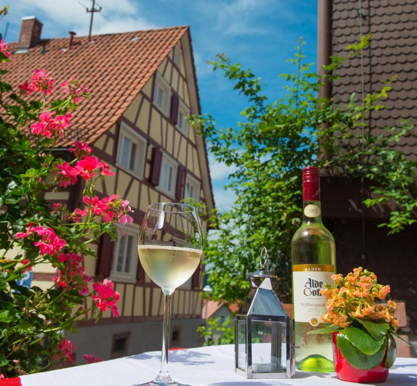 una botella de vino blanco y una copa en una mesa en Gästehaus Sonne en Gernsbach