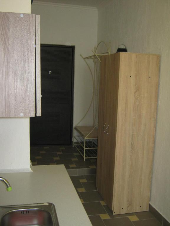 a kitchen with a sink and a wooden cabinet at Мини отель П88/1 in Odesa