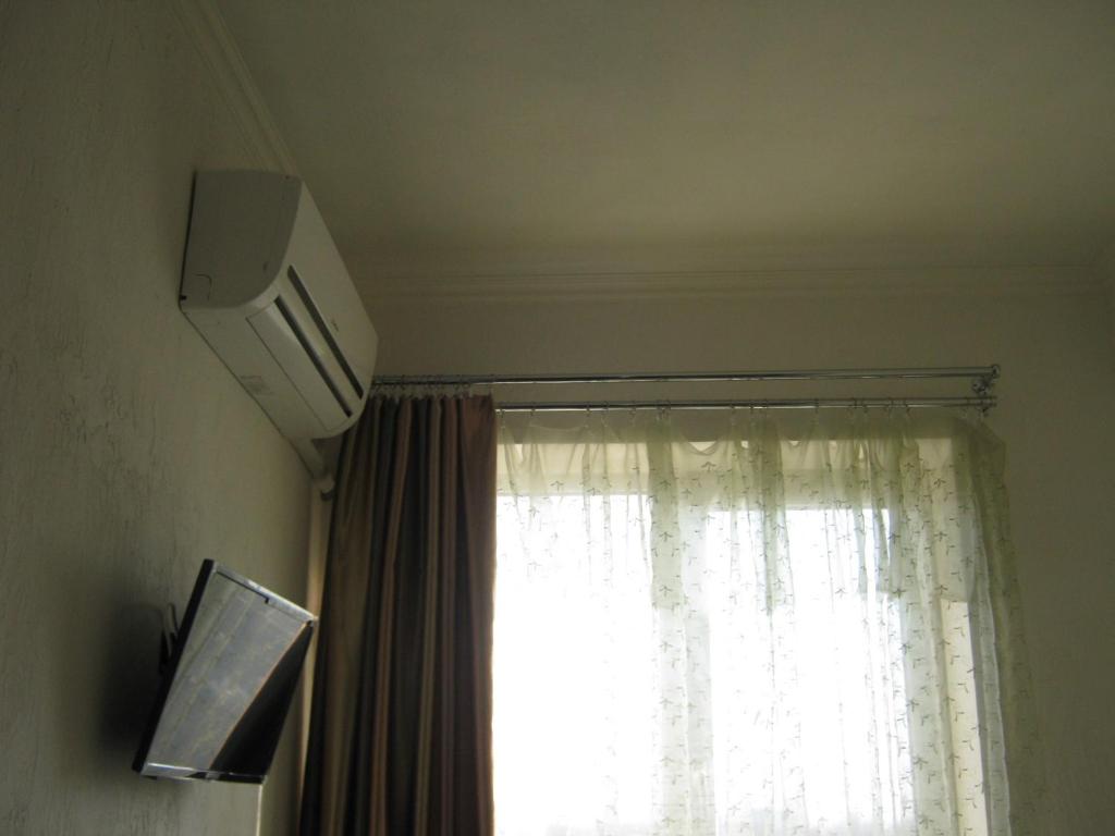 ein Fenster mit einem weißen Vorhang und einem TV in der Unterkunft Мини отель П88/1 in Odessa