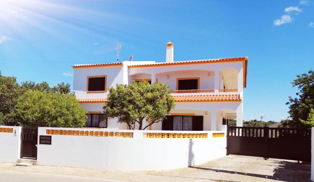 una casa blanca con una valla blanca en Vivenda Ribeiro, en Lagos