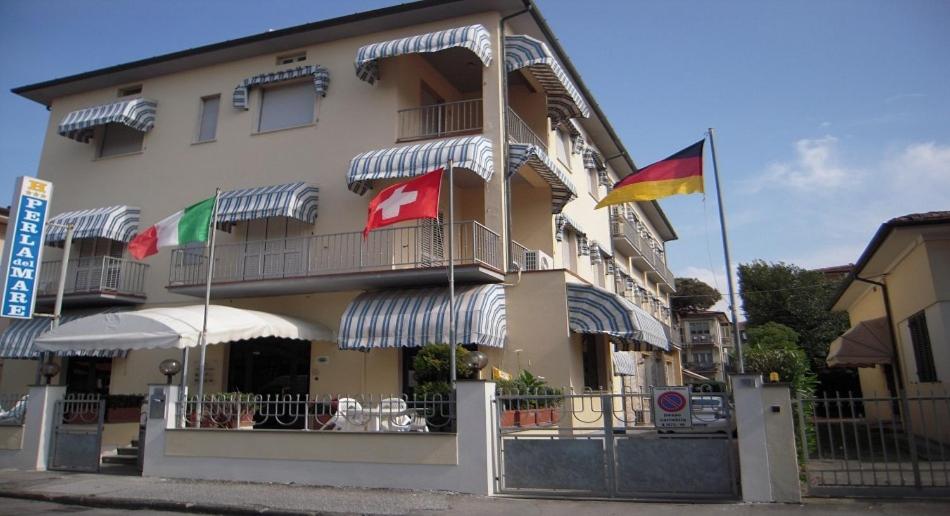 un edificio con banderas delante en Hotel Perla Del Mare, en Lido di Camaiore