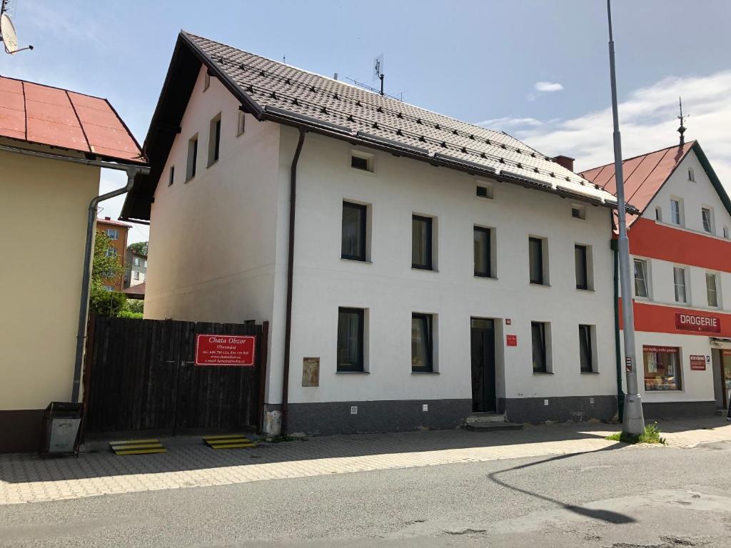 a white building on the side of a street at Chata Obzor in Železná Ruda