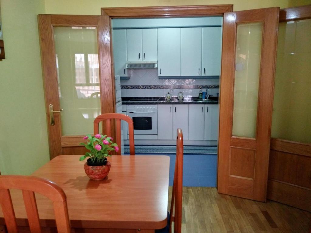 a kitchen with a wooden table with a vase of flowers on it at Amplio Loft con plaza de garaje in Cangas de Onís
