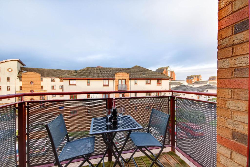 a balcony with two chairs and a table on a balcony at No 7 Ayr Beach - Coorie Doon in Ayr