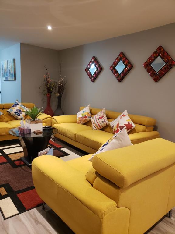 a living room with yellow couches and a table at Serendib Bed and Breakfast in Stratford