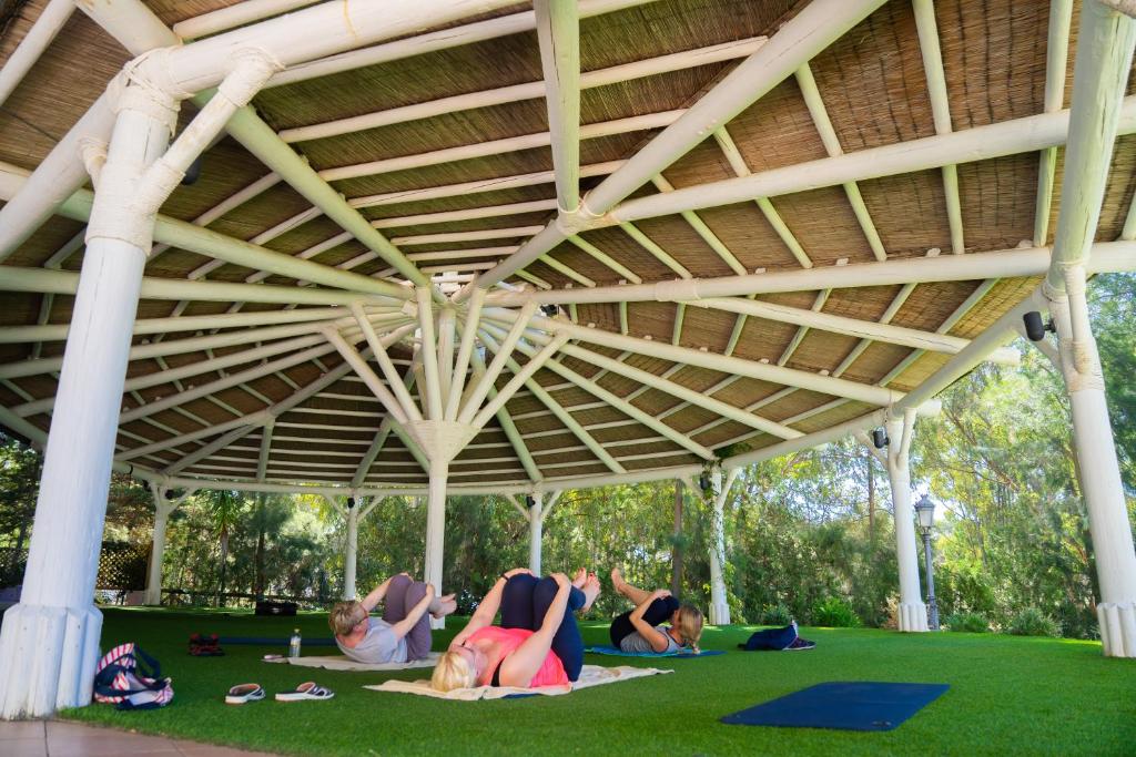 a group of people laying on the grass under a pavilion at TUI Blue Isla Cristina Palace - Adults Recommended in Isla Cristina