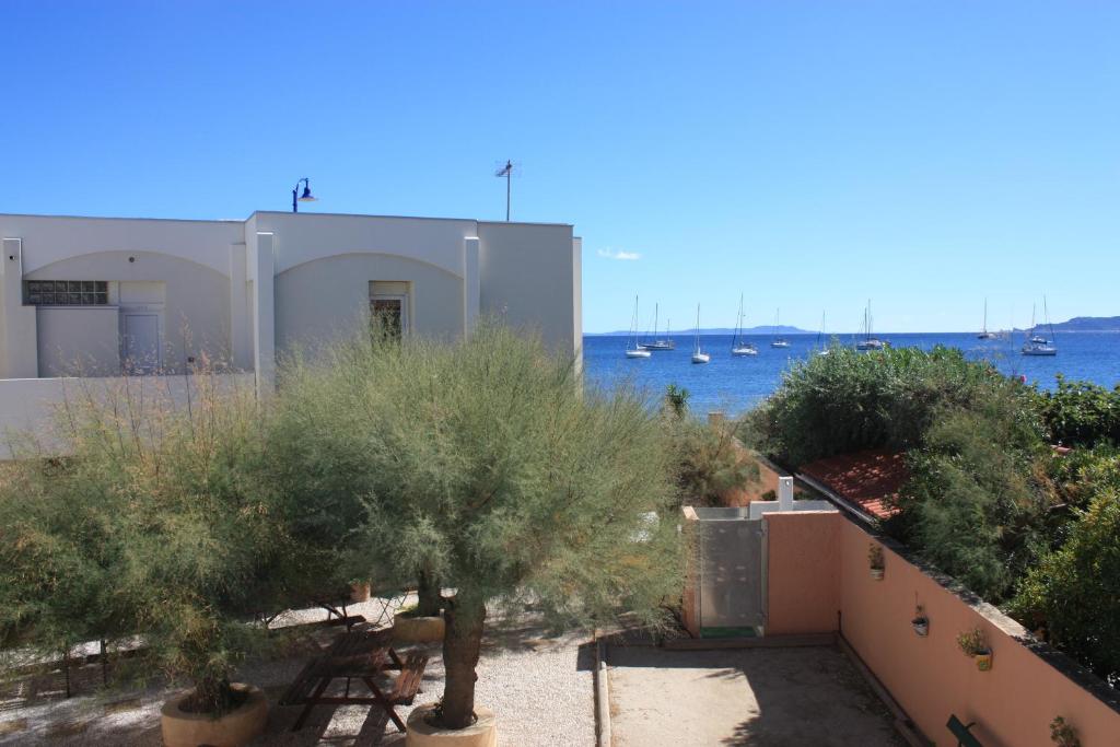 a view of a building with trees and the water at Les Stoechades in Hyères