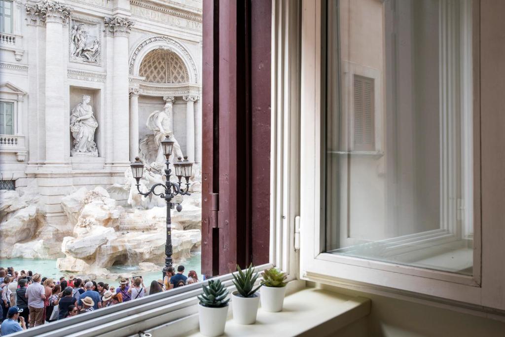 a window with a view of the trevi fountain at Trevinest Rome - Trevi Fountain Experience Unique View in Rome