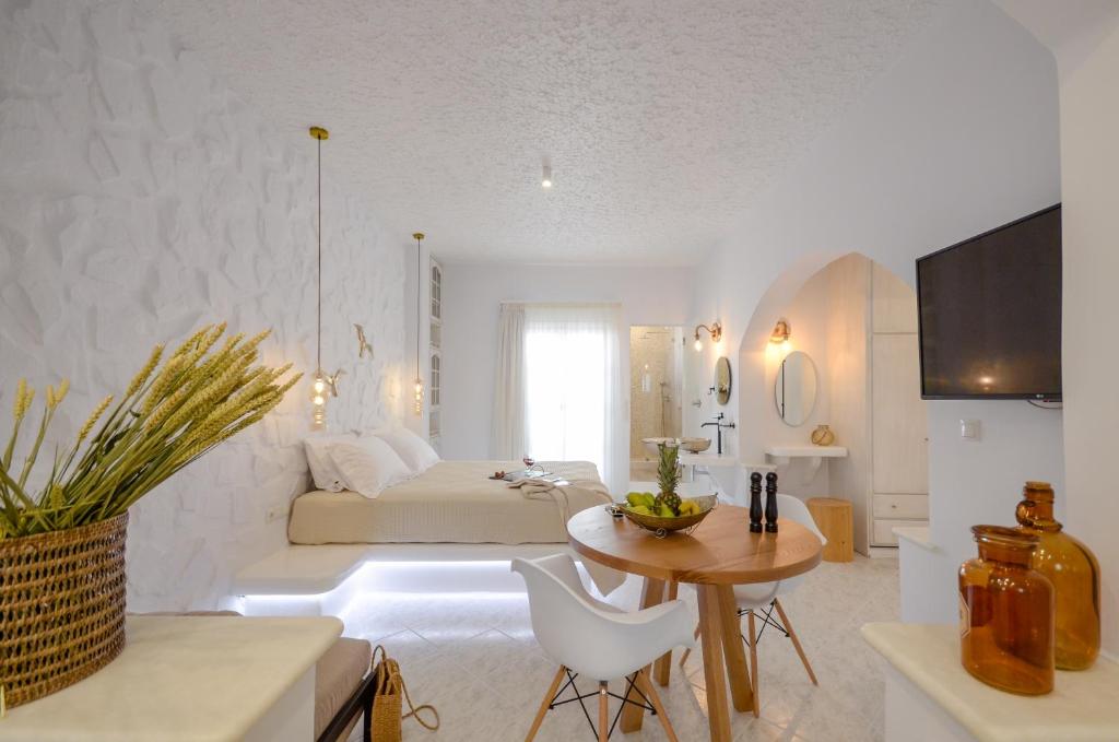 a large white room with a bed and a table at Smirida Suites in Naxos Chora