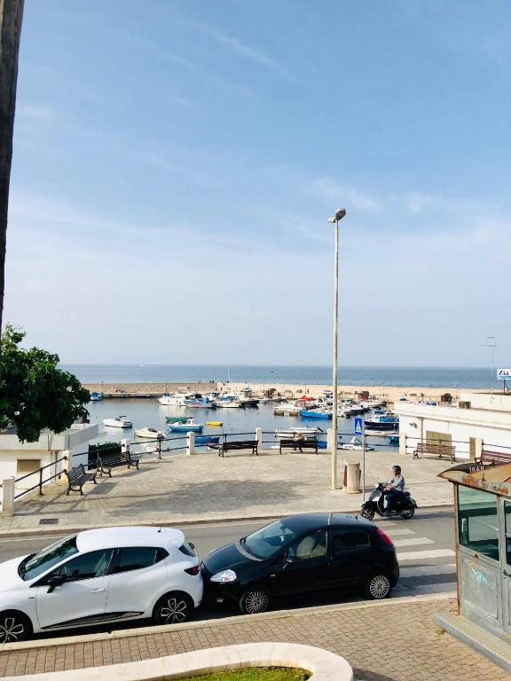 two cars parked in a parking lot near the water at Relax House in Bari