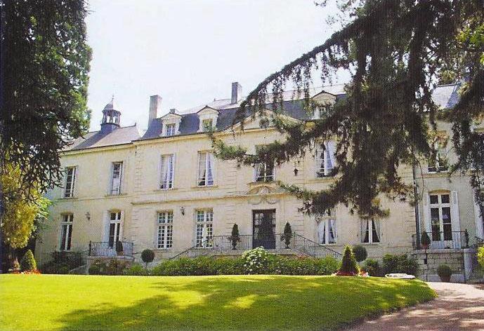 een groot wit huis met een gazon ervoor bij Château de Beaulieu in Saumur