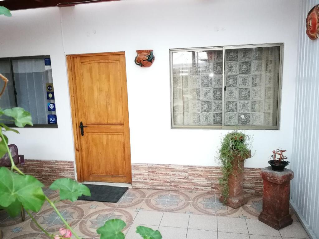 Casa con puerta de madera y ventana en Apart Guest Iquique, en Iquique