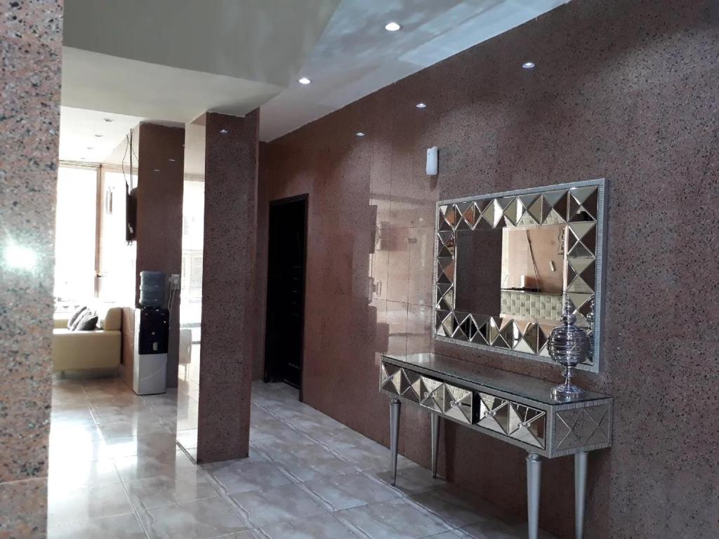 een kamer met een spiegel aan de muur bij Zaer Al Fakhama Hotel Apartments in Tabuk