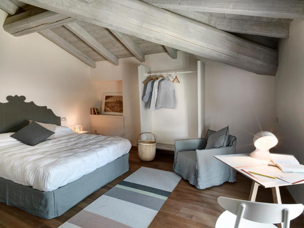 a bedroom with a bed and a chair and a table at Locanda Dei Nobili Viaggiatori in Cavernago