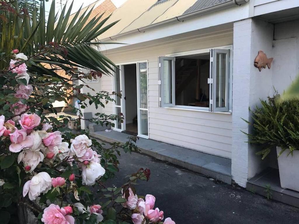 a house with pink roses in front of a window at Salt in Apollo Bay