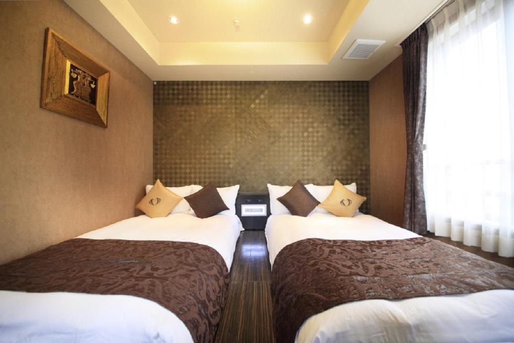 Cette chambre comprend 2 lits et une fenêtre. dans l'établissement Hotel Coco Grand Kitasenju, à Tokyo