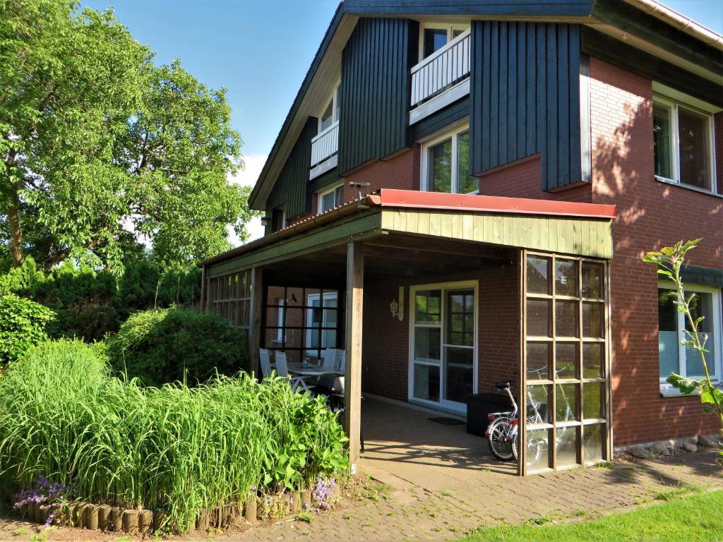 ein rotes Backsteinhaus mit einem Fahrrad davor geparkt in der Unterkunft Ferienwohnung Elbe Diek in Stelle