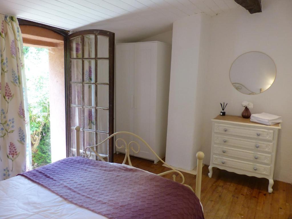 a bedroom with a bed and a dresser and a mirror at Hameau de Montcabirol - Foix in Mirepoix