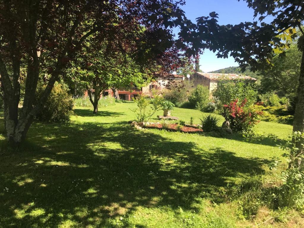 a yard with trees and green grass and a house at Hameau de Montcabirol - Foix in Mirepoix