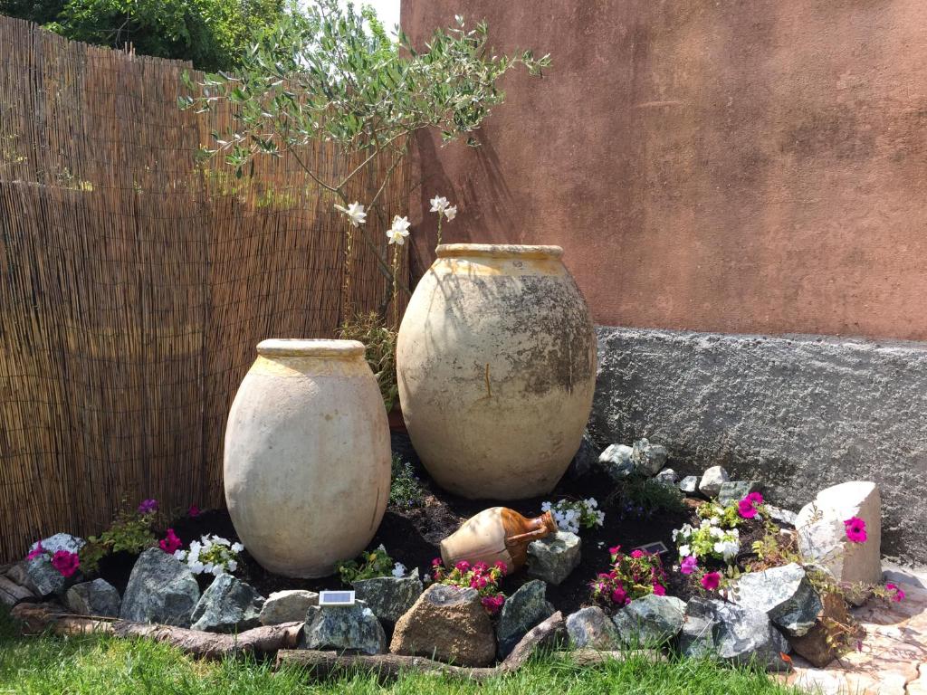 2 grands vases en ciment installés dans un jardin dans l'établissement Le Giare B&B, à Levanto