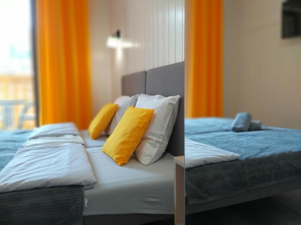 a bedroom with two beds with yellow pillows at PRZYSTANEK PIENINY in Szczawnica