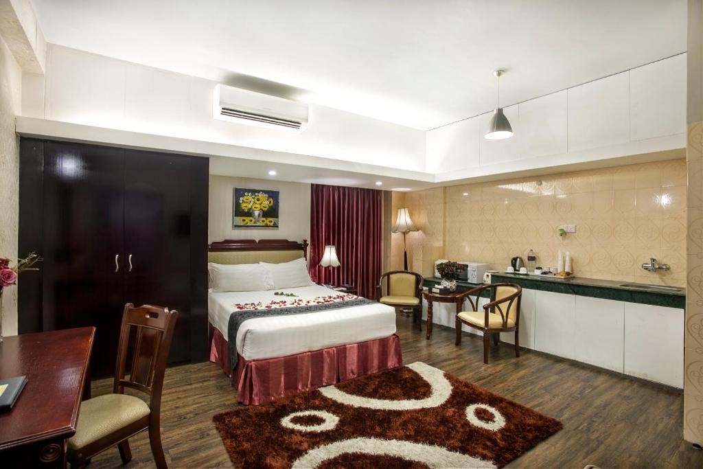 a hotel room with a bed and a kitchen at Hotel Highgarden in Dhaka