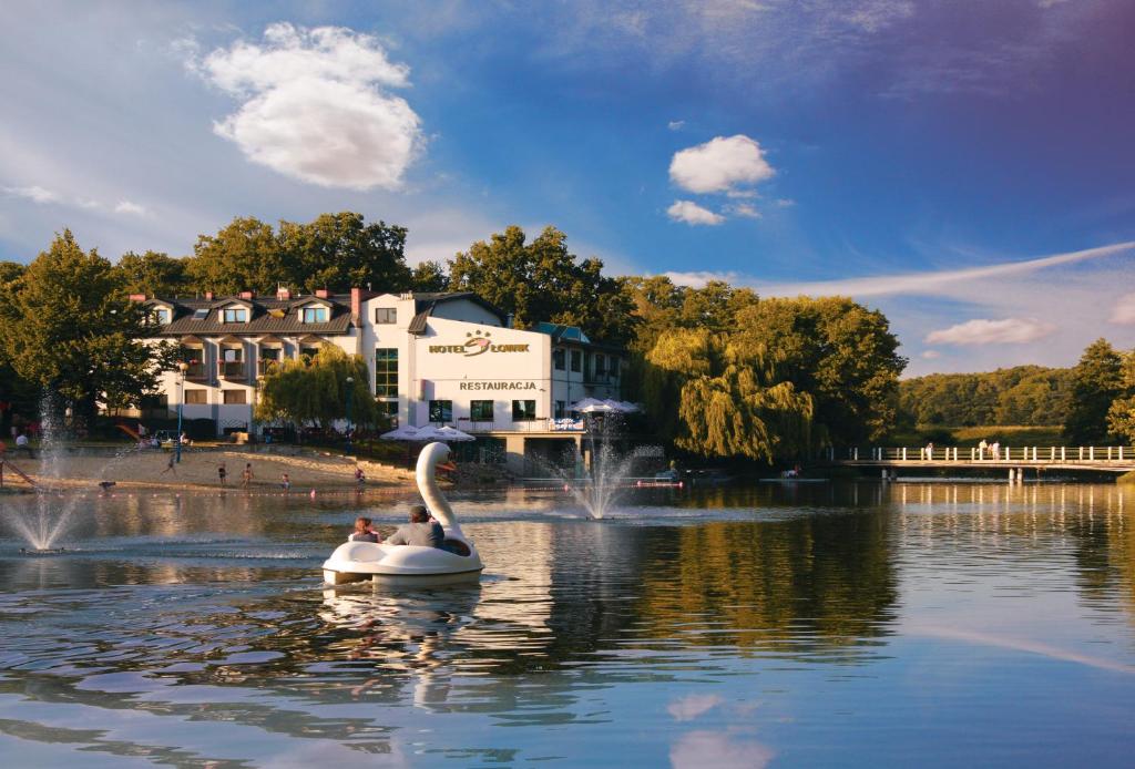 un cisne en un lago frente a un edificio en Hotel Słowik, en Poniatowa