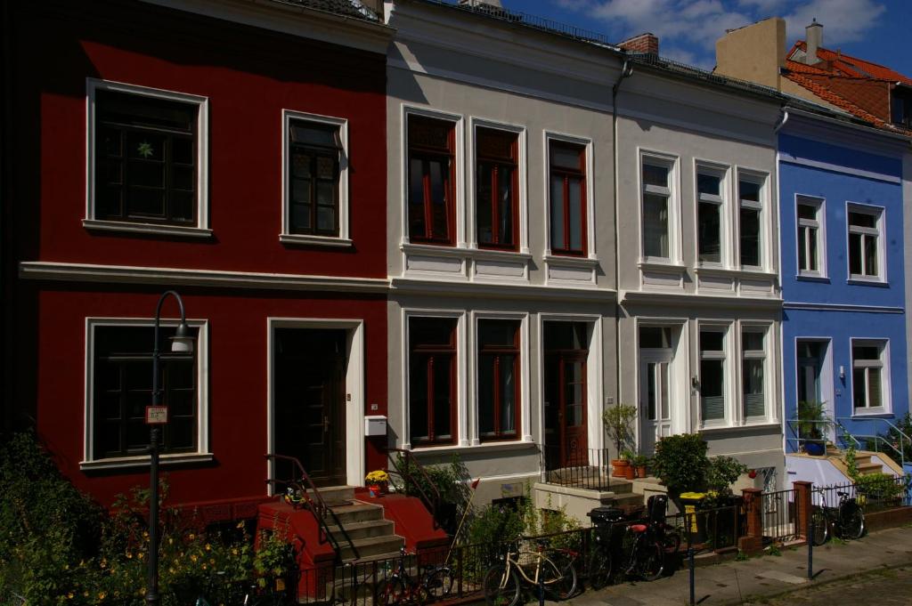 una casa roja blanca y azul con bicicletas delante en Ferienwohnung Fesenfeld Bremen Steintorviertel, en Bremen